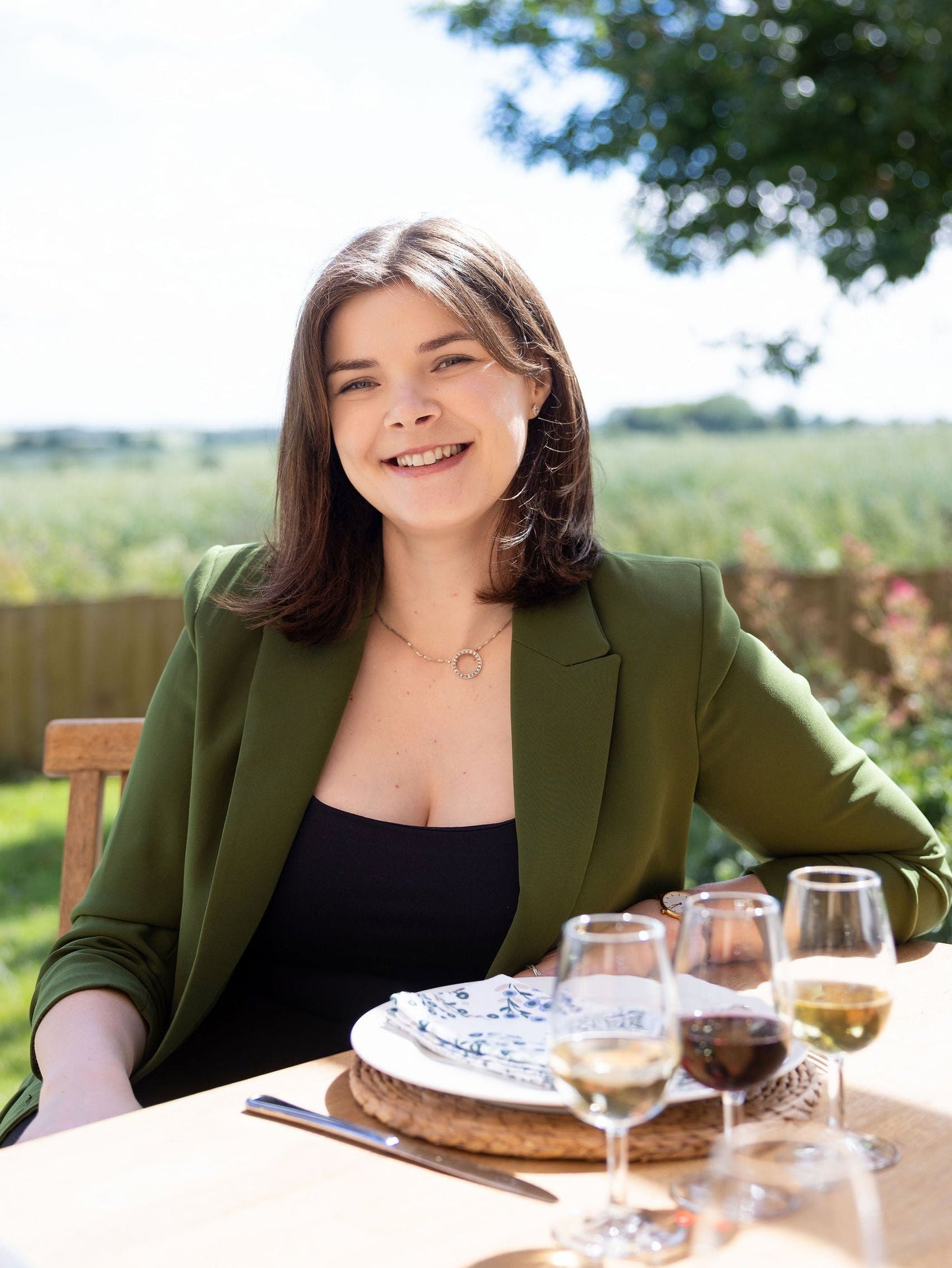 Victoria Bubb sitting at a table outdoors with a scenic background